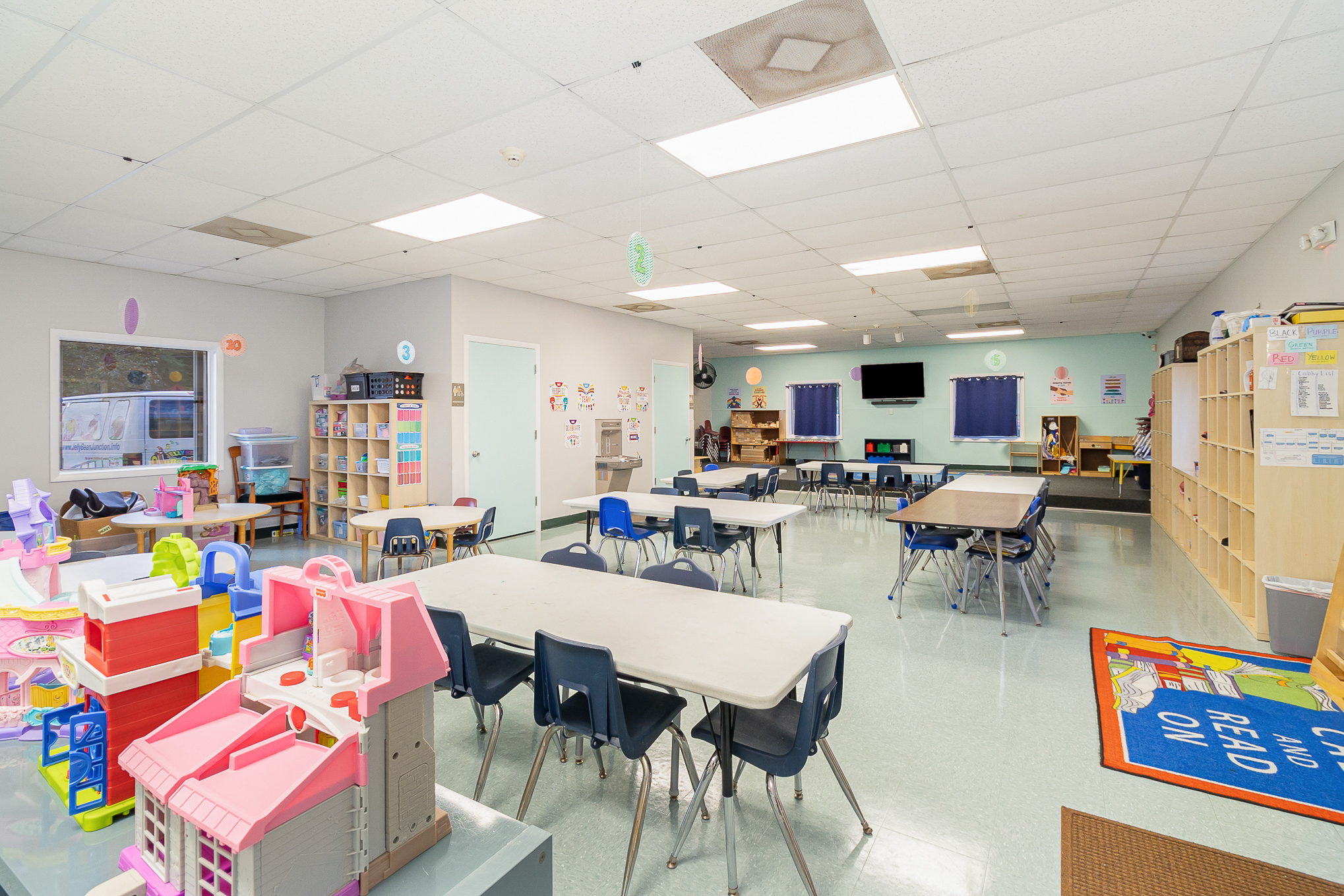 School age activity room with homework tables, board games, art supplies, and comfortable seating