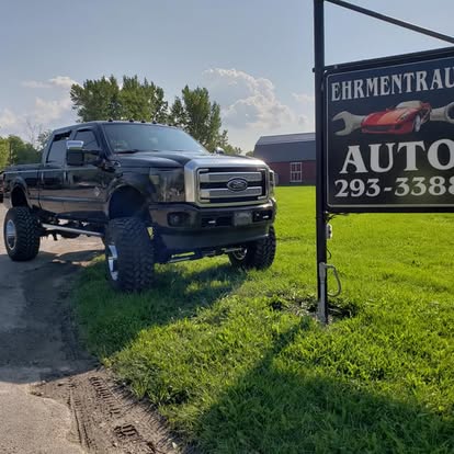 Lifted truck parked at Ehrmentraut Auto Repair shop sign