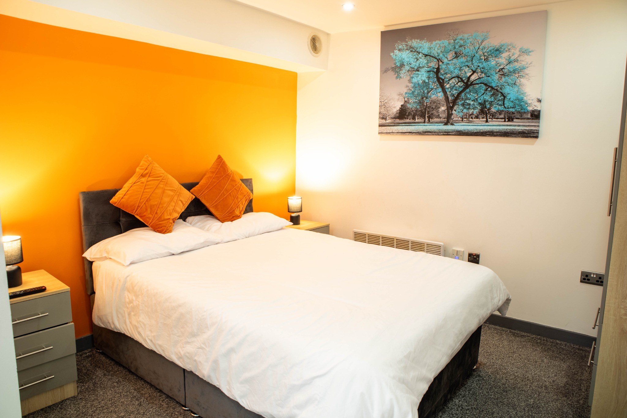 8A Piccadilly — comfortable double bed with orange feature wall