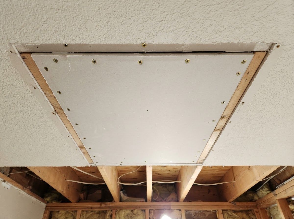 Ceiling drywall patch secured before taping and finishing