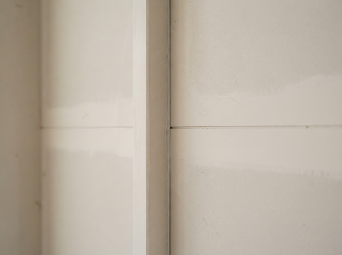 Smooth drywall joint finishing for a paint-ready wall