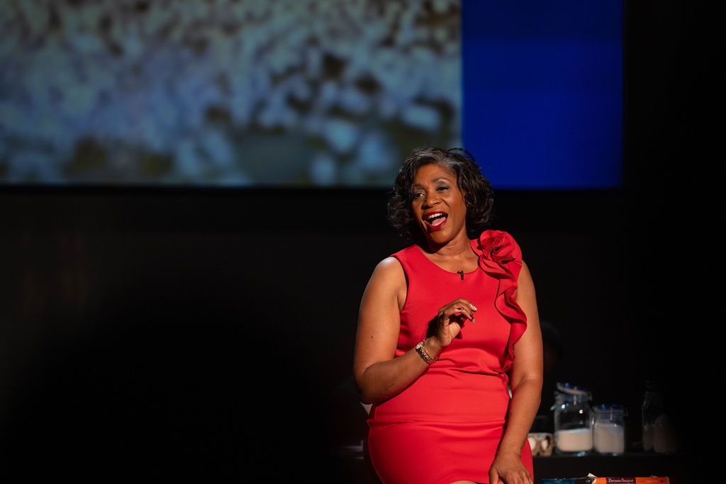 Dasha Kelly performing Makin' Cake on stage in red dress