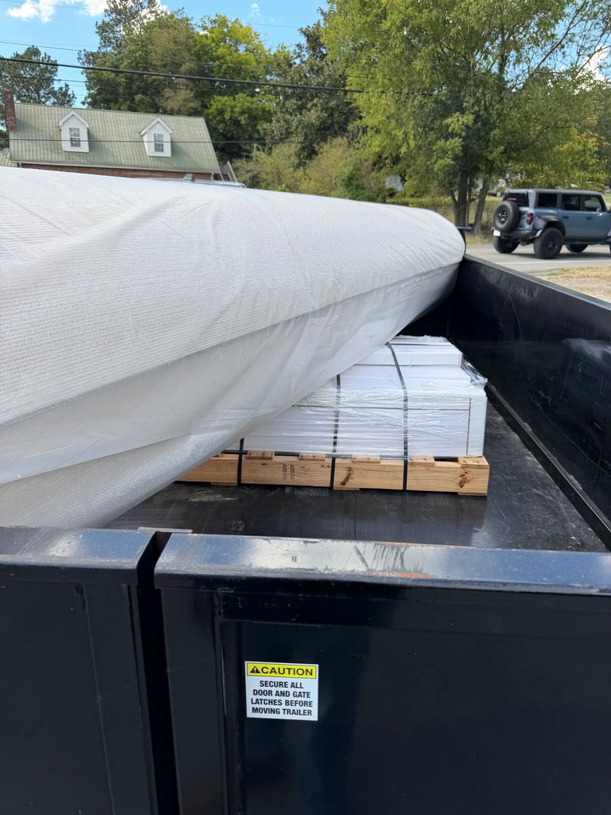 Covered carpet and flooring pallets on transport trailer