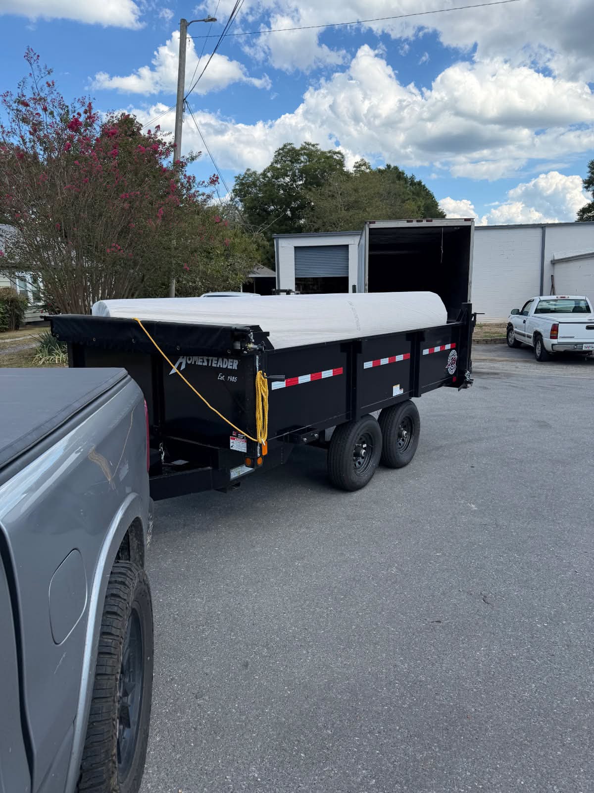 Hauling trailer packed with rolls of carpet and flooring materials