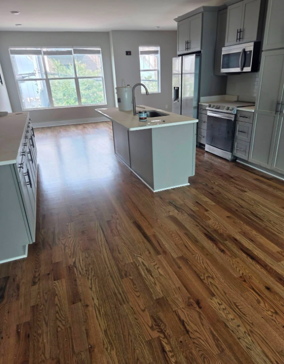 Refinished hardwood kitchen and open living space with island and warm wood grain finish