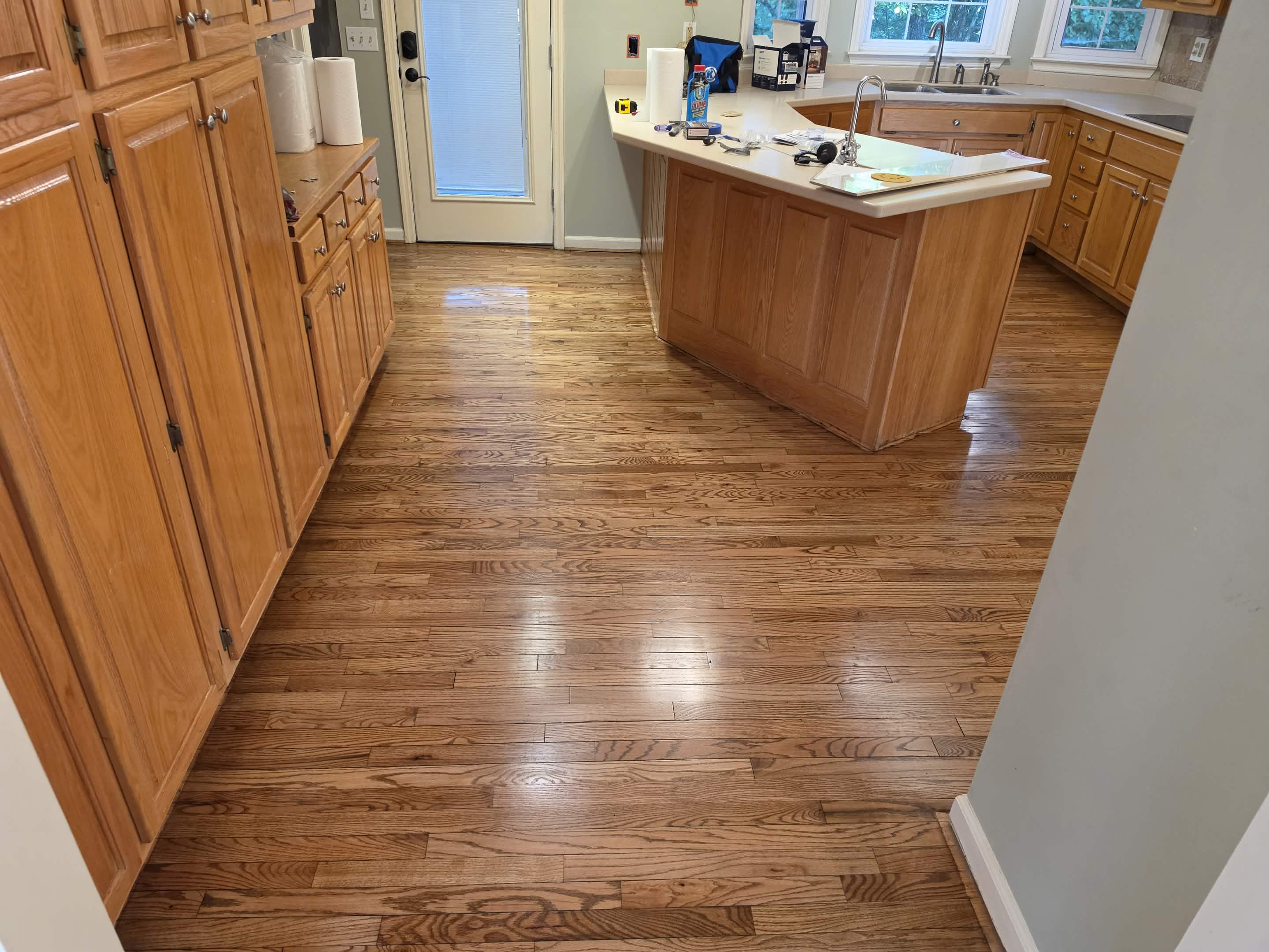 Gleaming refinished hardwood kitchen floors with custom oak cabinets and center island