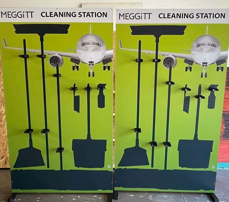 Meggitt Cleaning Station twin aerospace shadow boards with jetliner graphic, high-visibility green backing, and brackets for squeegees, brooms, and spray bottles