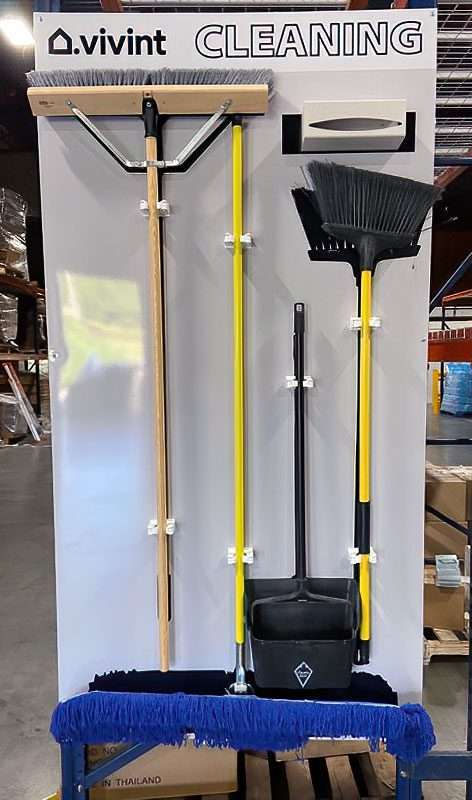 Vivint Cleaning Station rack-mounted warehouse shadow board with push broom, squeegee, angle broom, upright lobby dustpan, dust mop, and wipe dispenser