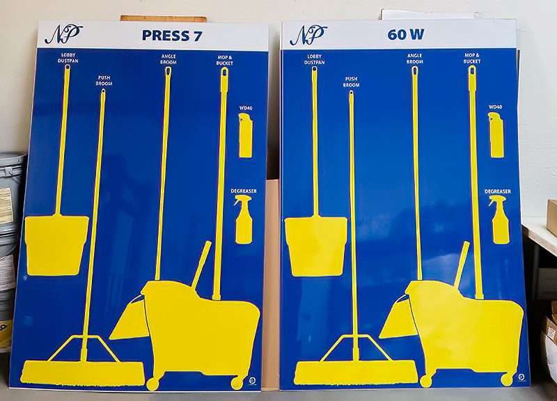 NP Press 7 and 60 W matching blue cleaning stations with high-contrast yellow silhouettes for push broom, angle broom, dustpan, WD-40, degreaser, and mop bucket