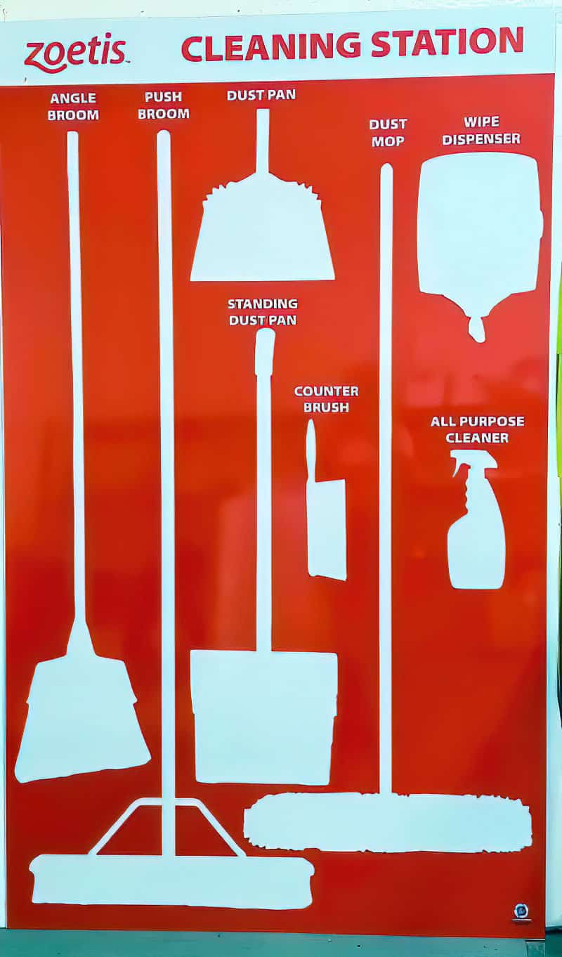 Zoetis animal health facility custom red cleaning station shadow board with white tool silhouettes and designated item labels