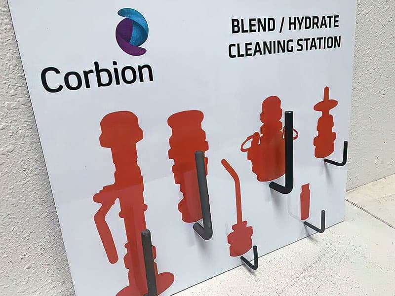 Corbion Blend and Hydrate Cleaning Station shadow board with heavy-duty coated L-hooks and orange silhouettes for sanitary washdown nozzles, valves, and fittings