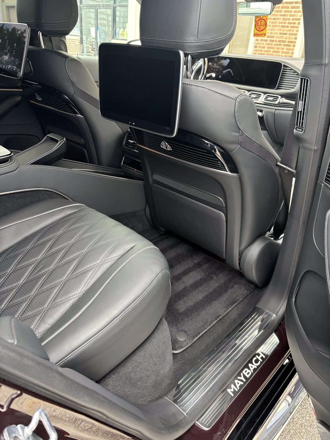 Detailed luxury Maybach rear passenger cabin with diamond-stitched leather seating and pristine carpet