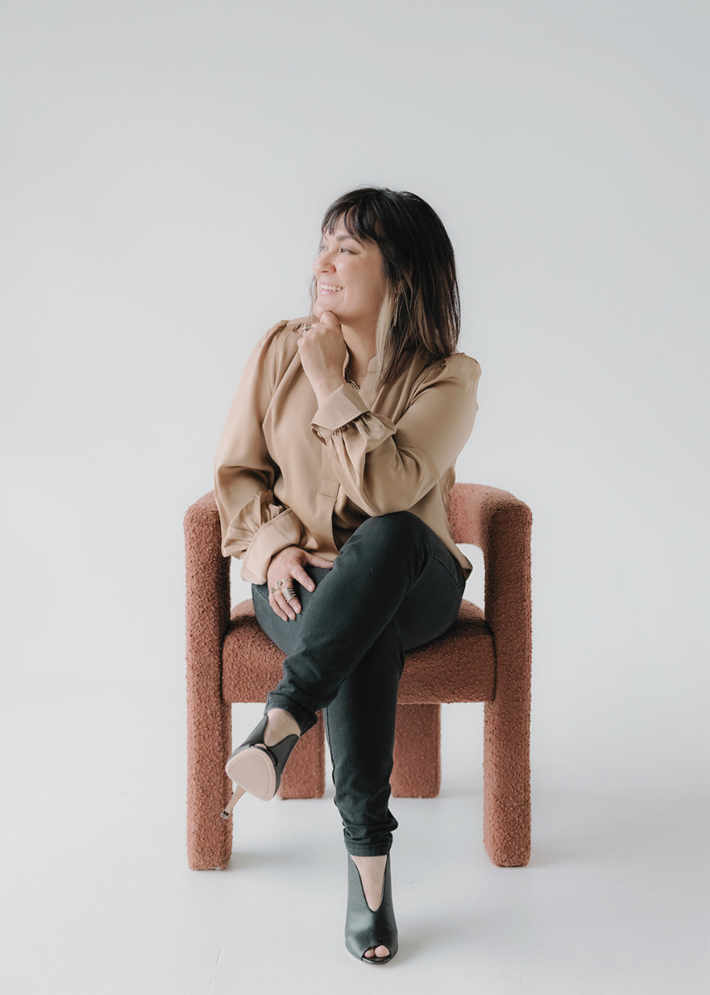 Joaquina Mascuch seated thoughtfully in modern clay armchair