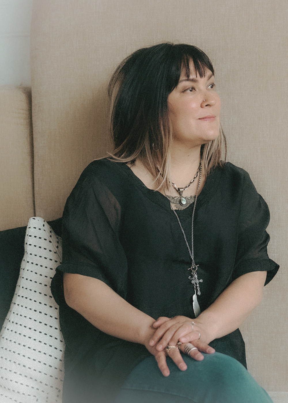Joaquina Mascuch — quiet, reflective portrait with talisman jewelry