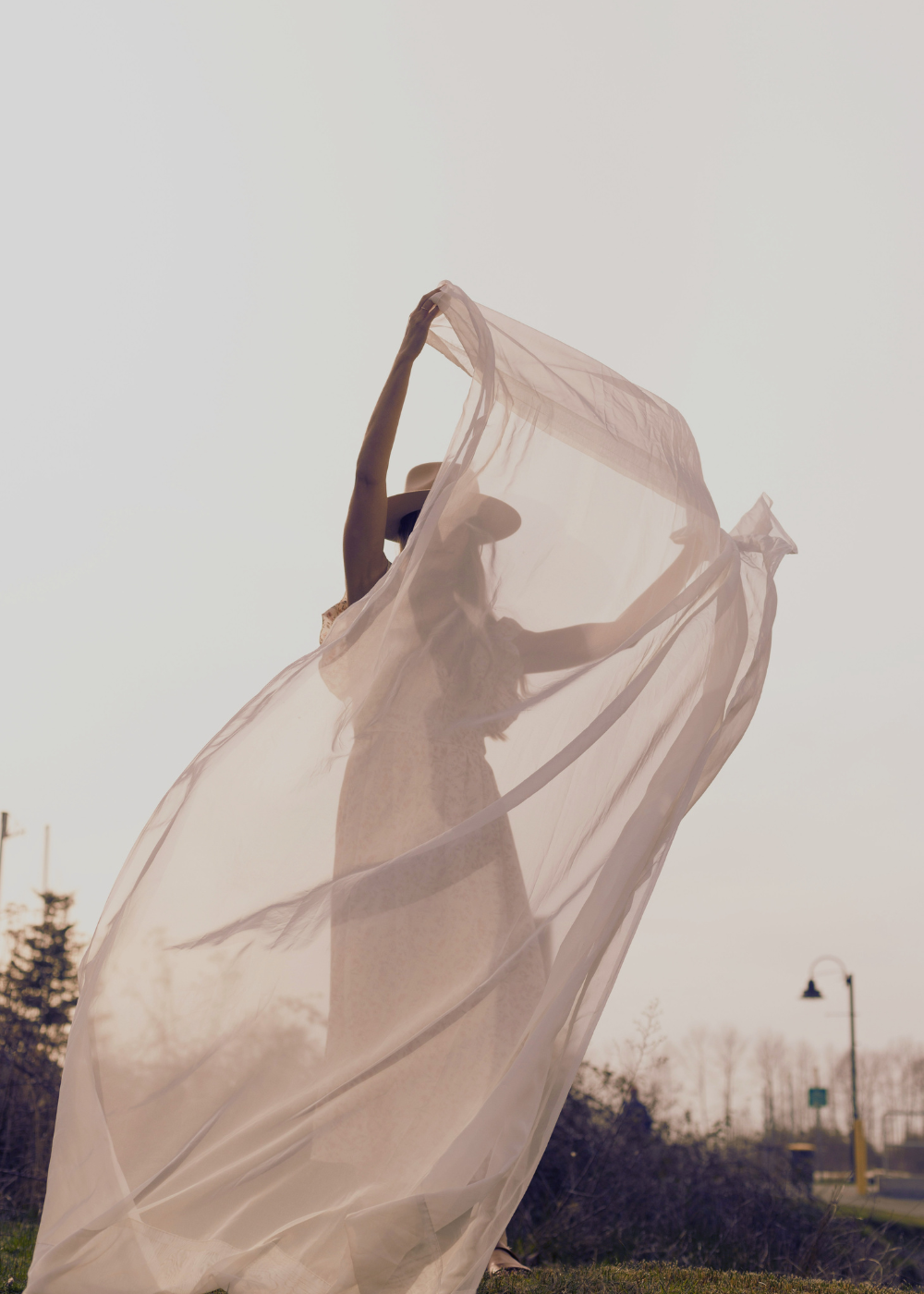 Woman with flowing sheer veil in open air, symbolizing veils, protection, and breaking the spell