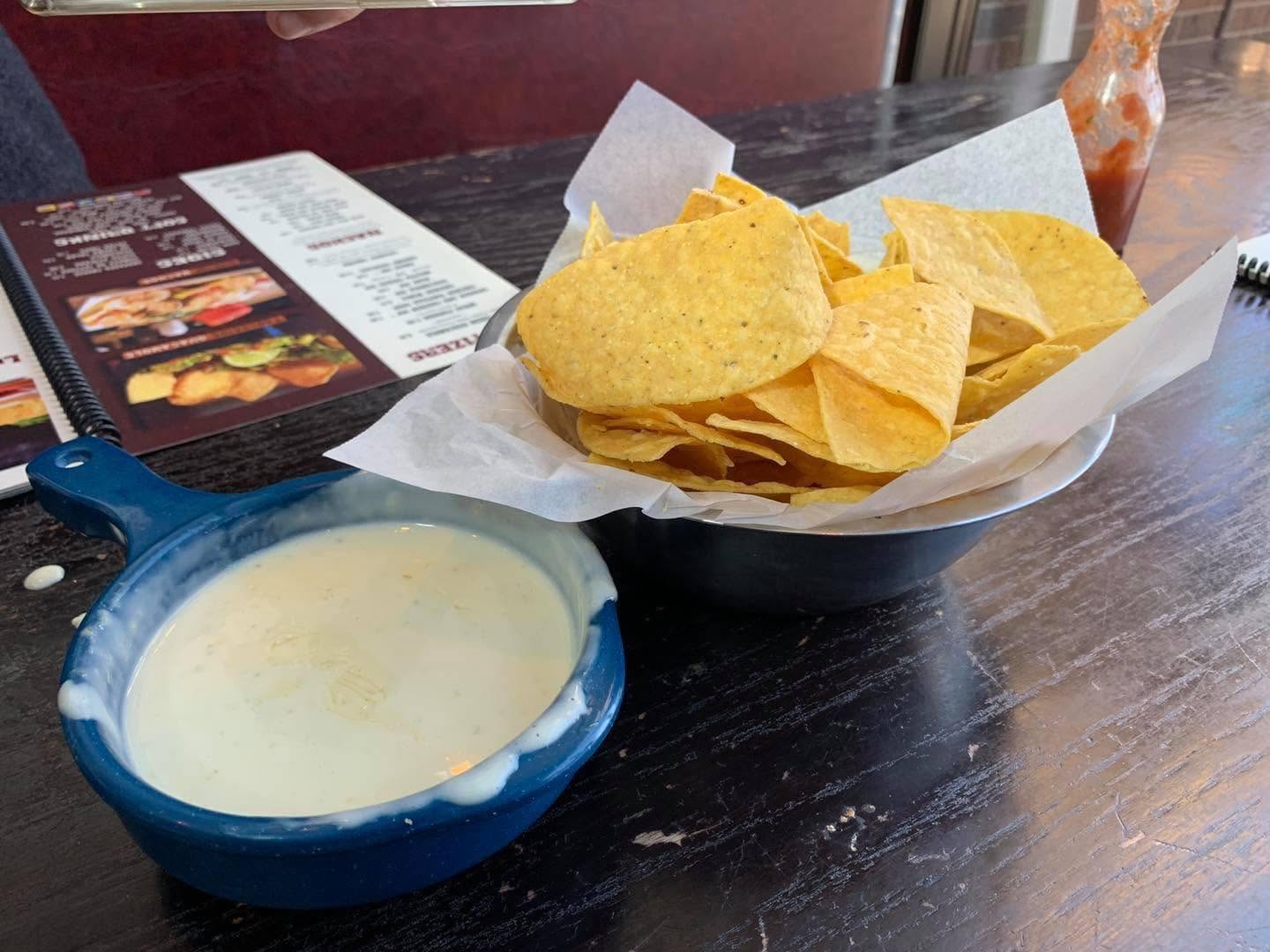 Golden tortilla chips served with smooth melted queso dip