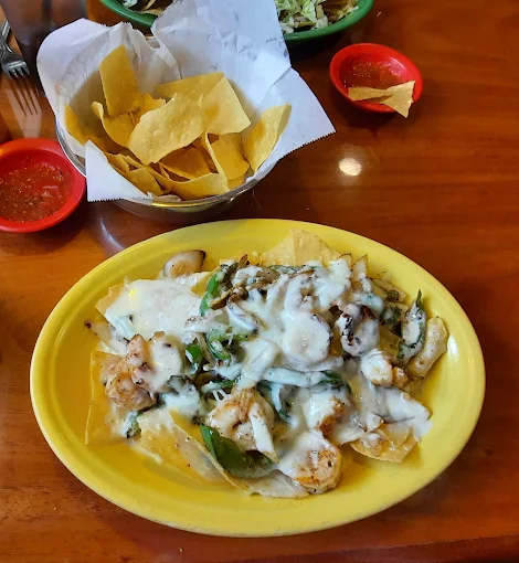 Generous platter of loaded shrimp nachos with melted cheese dip and chips at Casa Grande in Hicksville