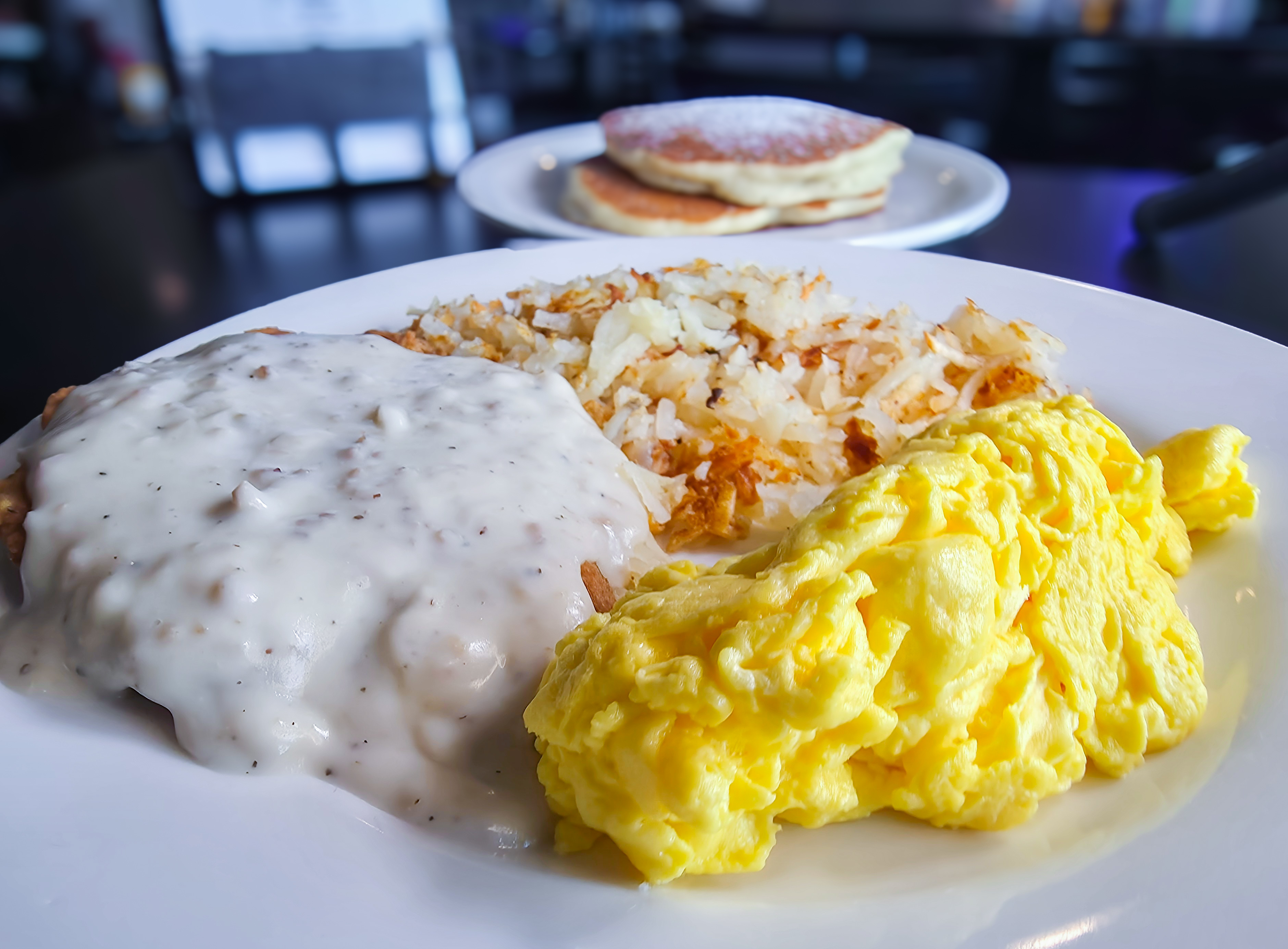 All day breakfast platter with eggs, hash browns, biscuits and gravy, and pancakes at 4Korners Restaurant