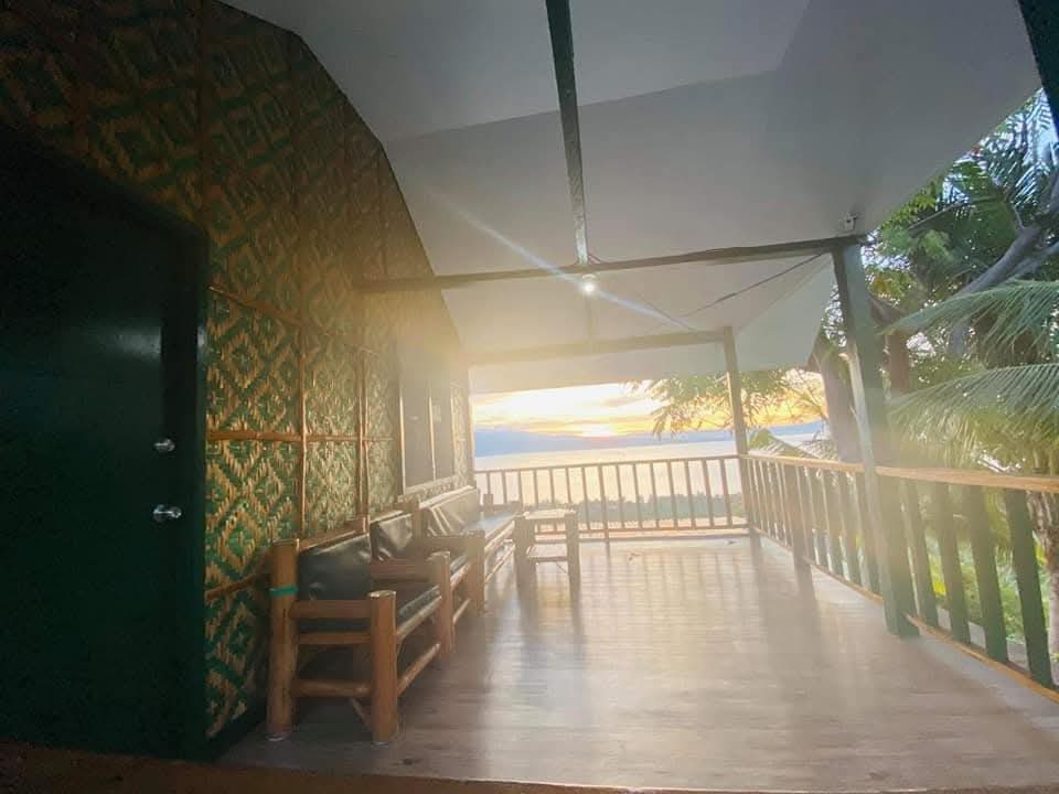 Covered veranda balcony at Mims House Cebu with bamboo chairs, amakan walls, and sunset view across the sea