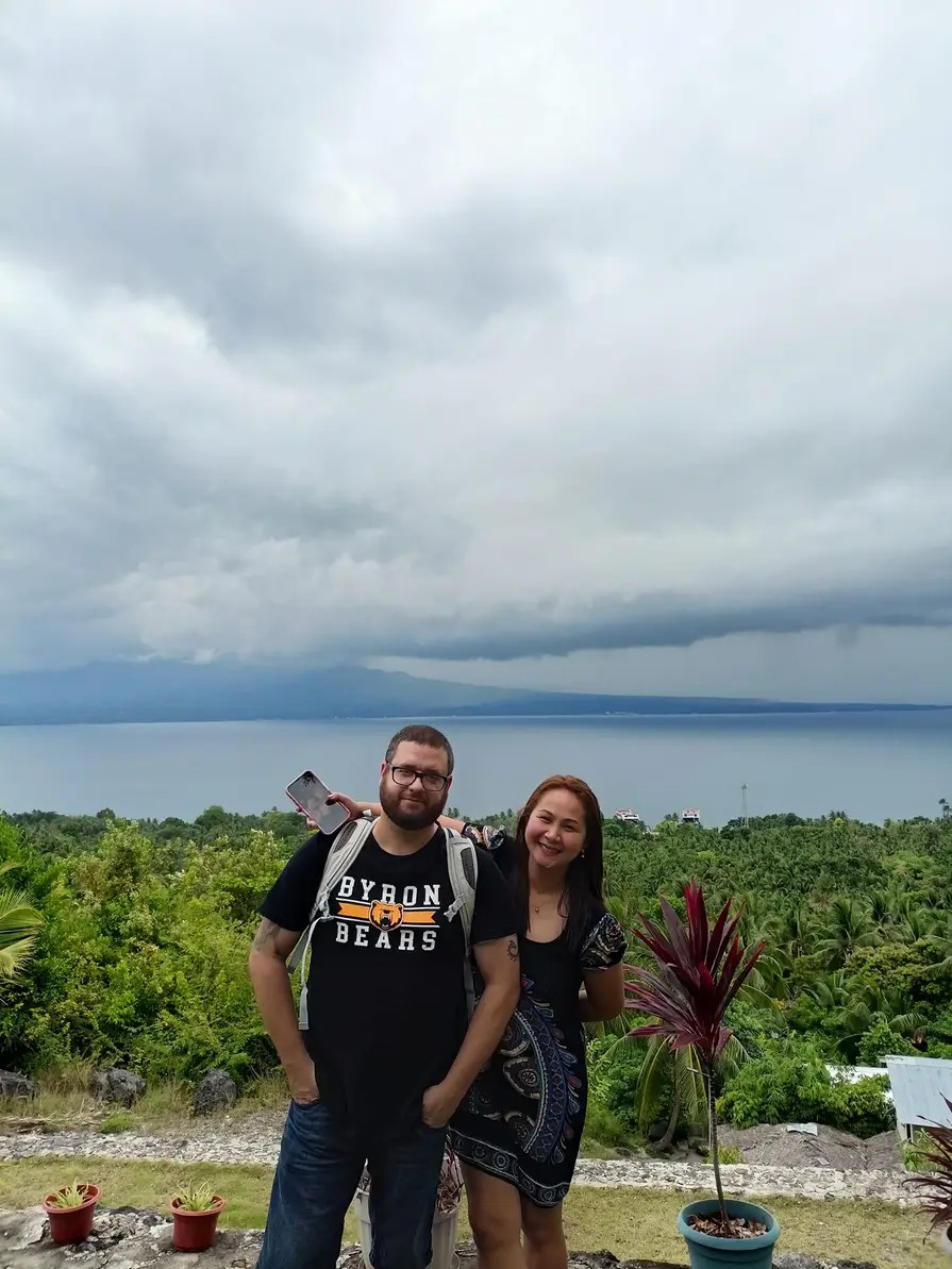 Guests on the stone terrace overlooking the sea and coconut tree canopies at Mims House Cebu