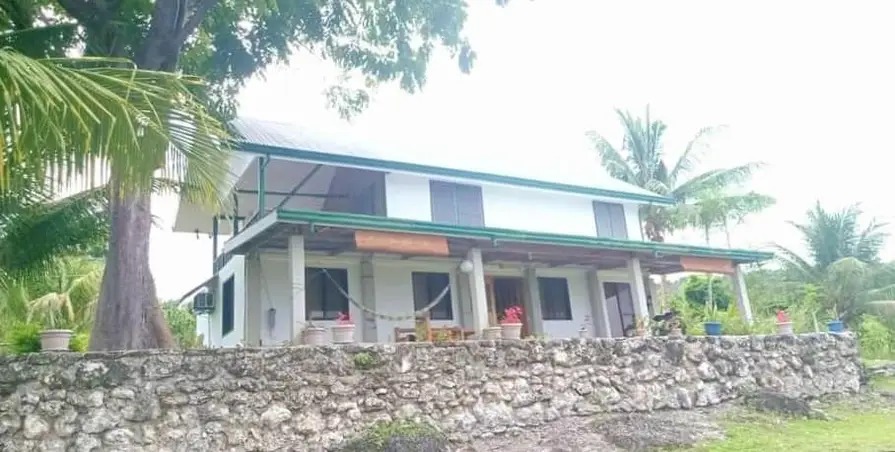 Mims House Cebu exterior showing covered porch, upper floor, and natural stone foundation in Samboan