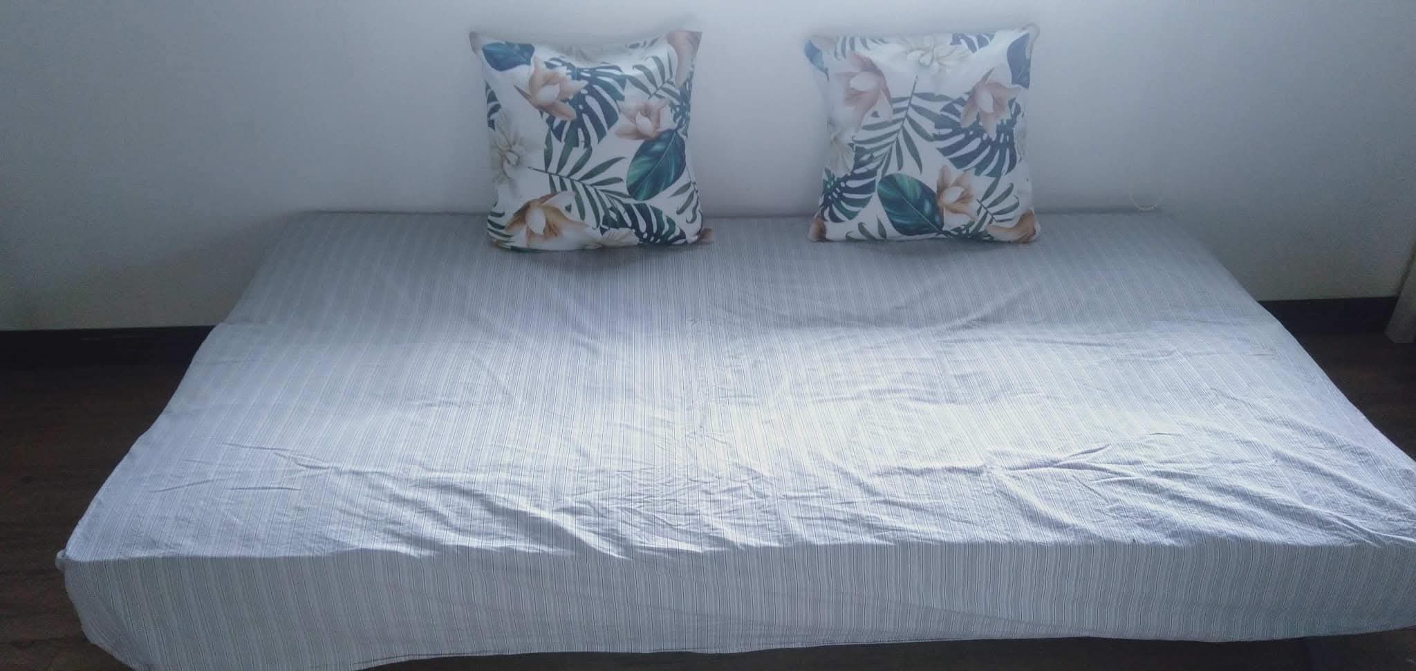 Additional daybed with striped cover and tropical monstera leaf accent pillows at Mims House Cebu