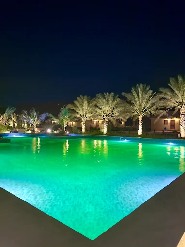 Glowing turquoise swimming pool reflection at night