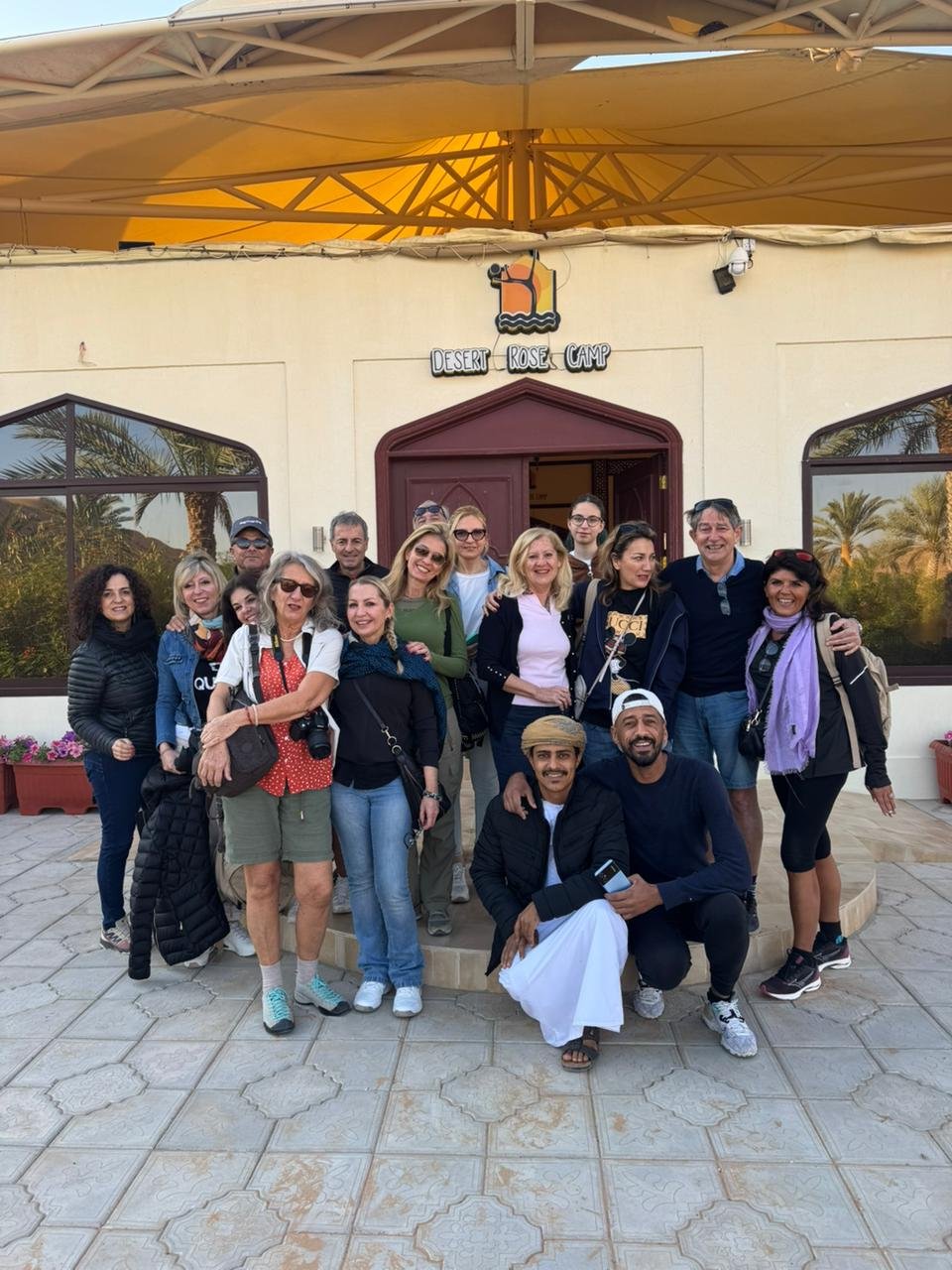 Group of happy guests gathered in front of the camp reception