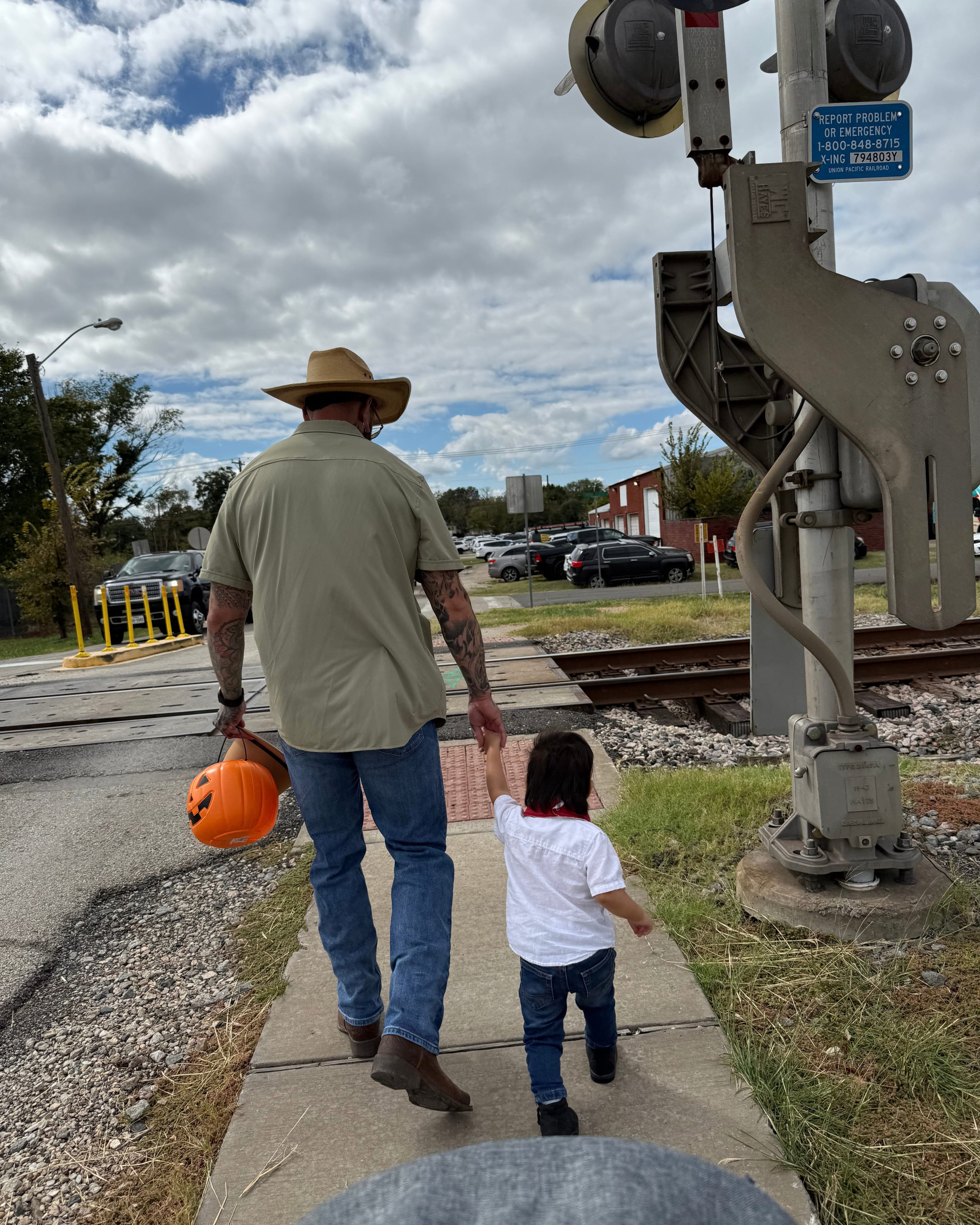 Sam Rodriguez walking hand-in-hand with his young son beside the railway tracks