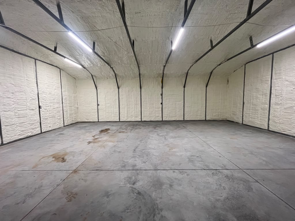 Clean metal building spray foam installation with overhead lighting by Coastal Synergy in Savannah GA