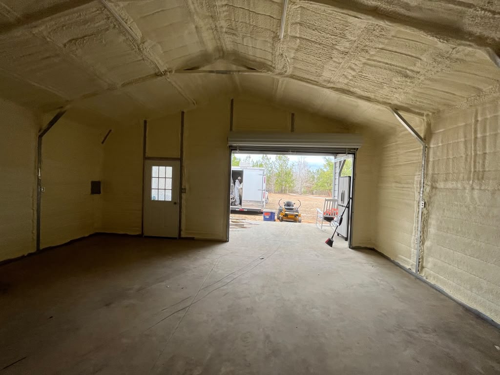 Commercial equipment garage spray foam insulation with open roll-up bay door in Statesboro GA