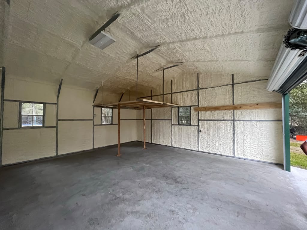 Wide-bay workshop spray foam insulation looking toward roll-up door in Pooler GA