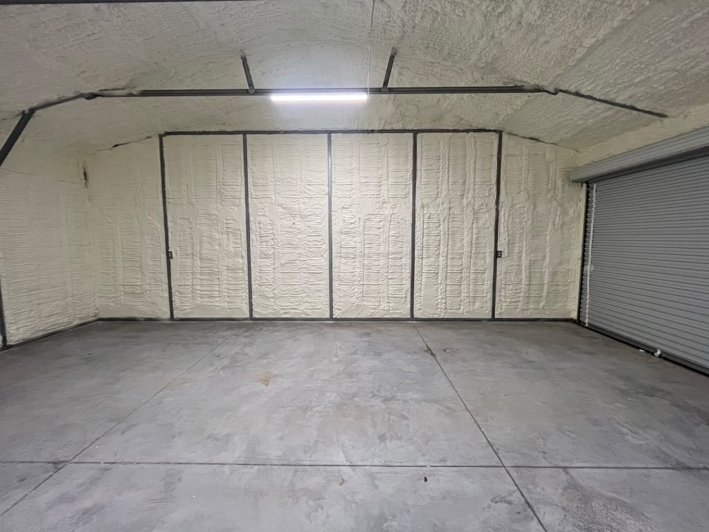 Rear wall and roofline spray foam seal next to roll-up door in Pooler GA