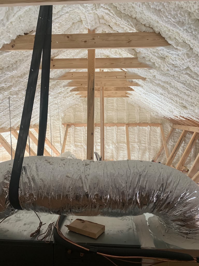 Spray foam insulation along roof deck and ductwork completed by Coastal Synergy in Statesboro GA