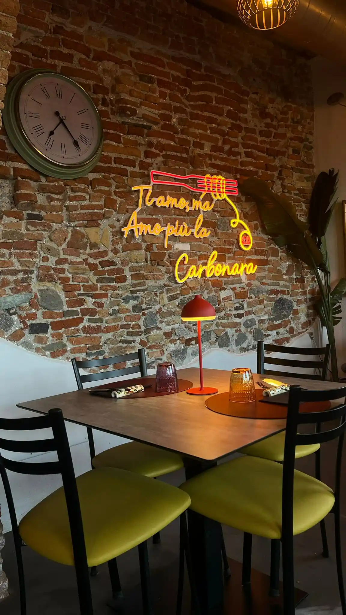Interno sala con mattoni a vista e neon Ti amo ma amo più la Carbonara
