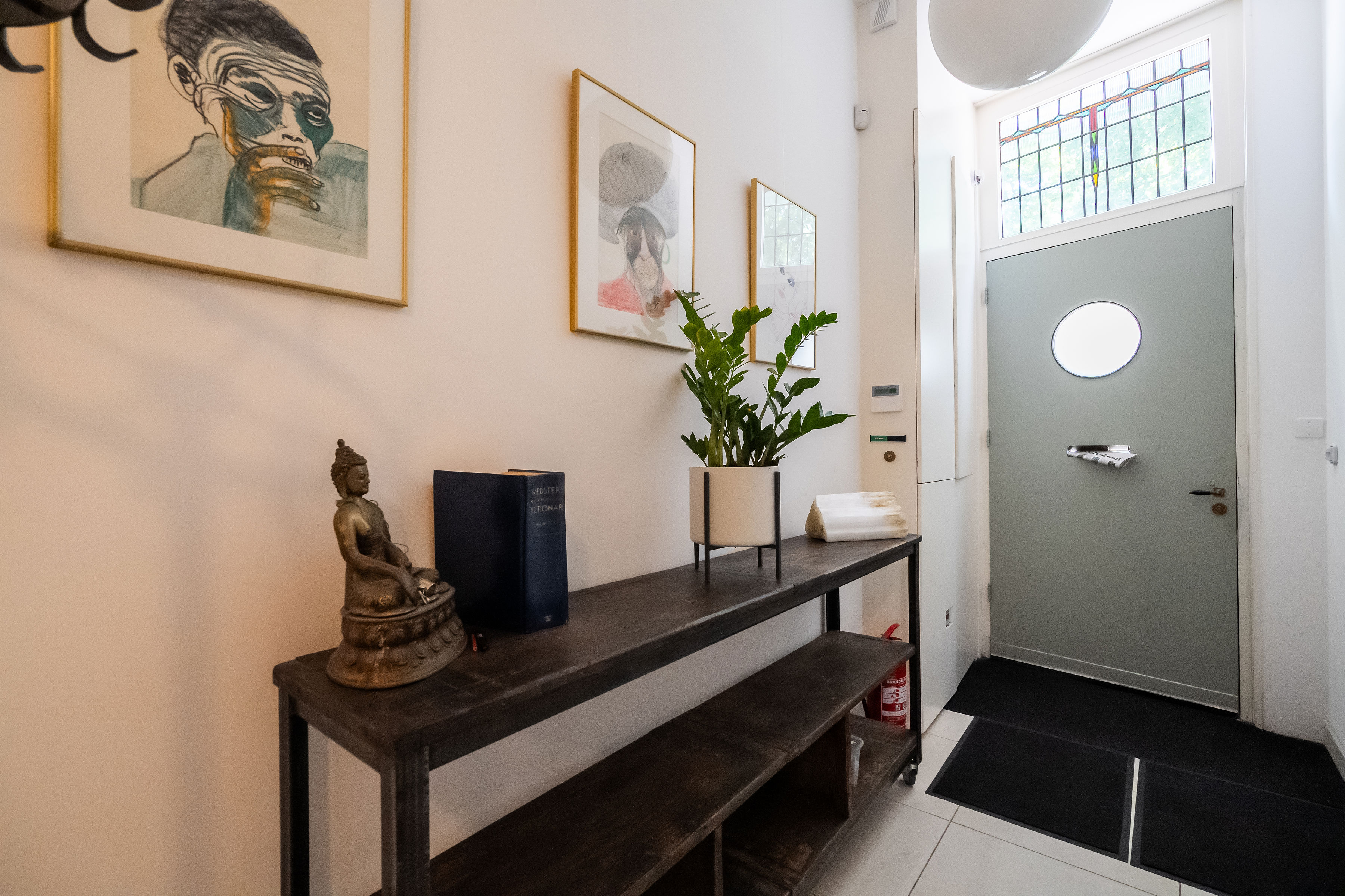 Stijlvolle entree en hal van een Utrechtse B&B met kunst, sfeervolle inrichting en glas-in-lood