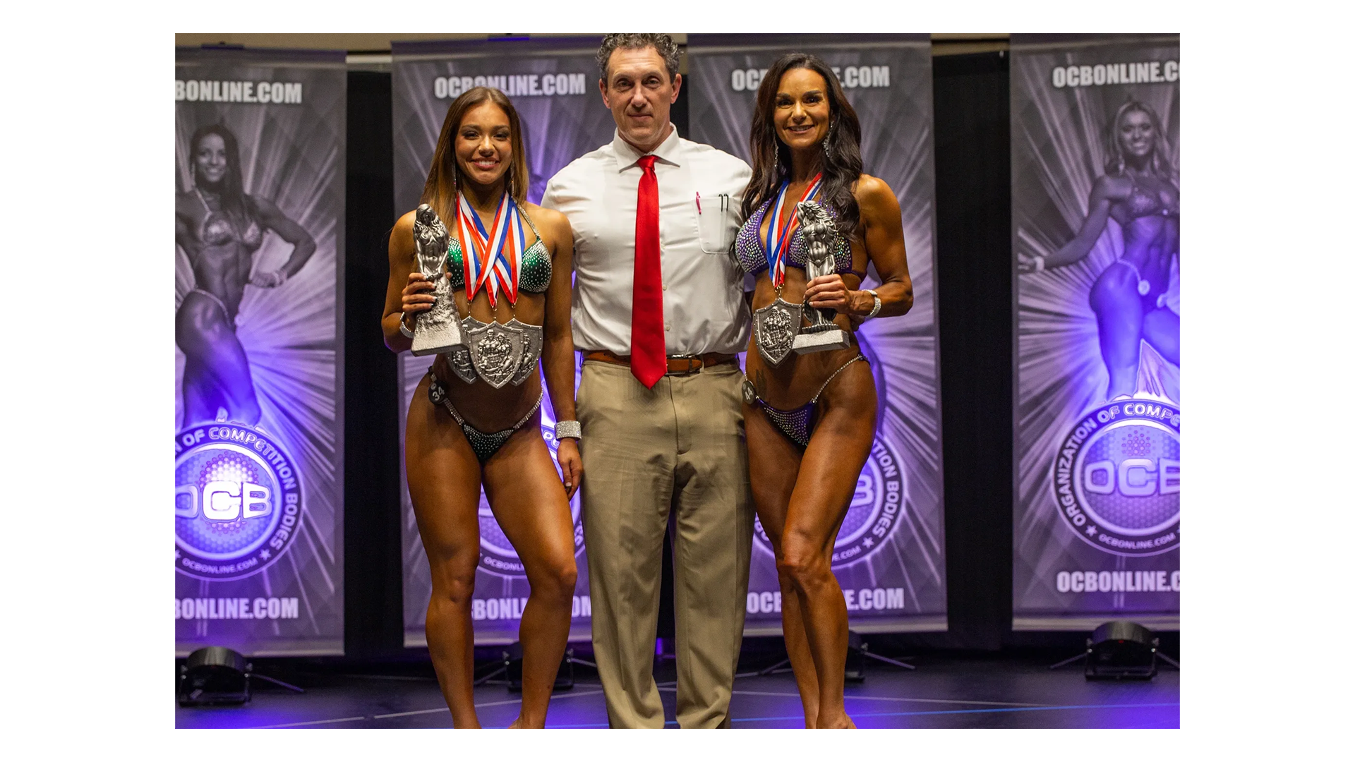 Fit Body Physiques competitors with medals on stage