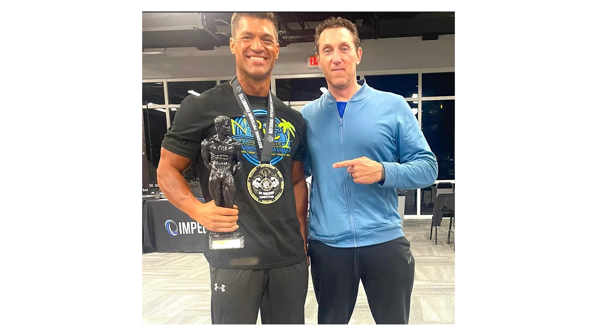 Coach Nate Eaton with champion competitor holding first place trophy and medal