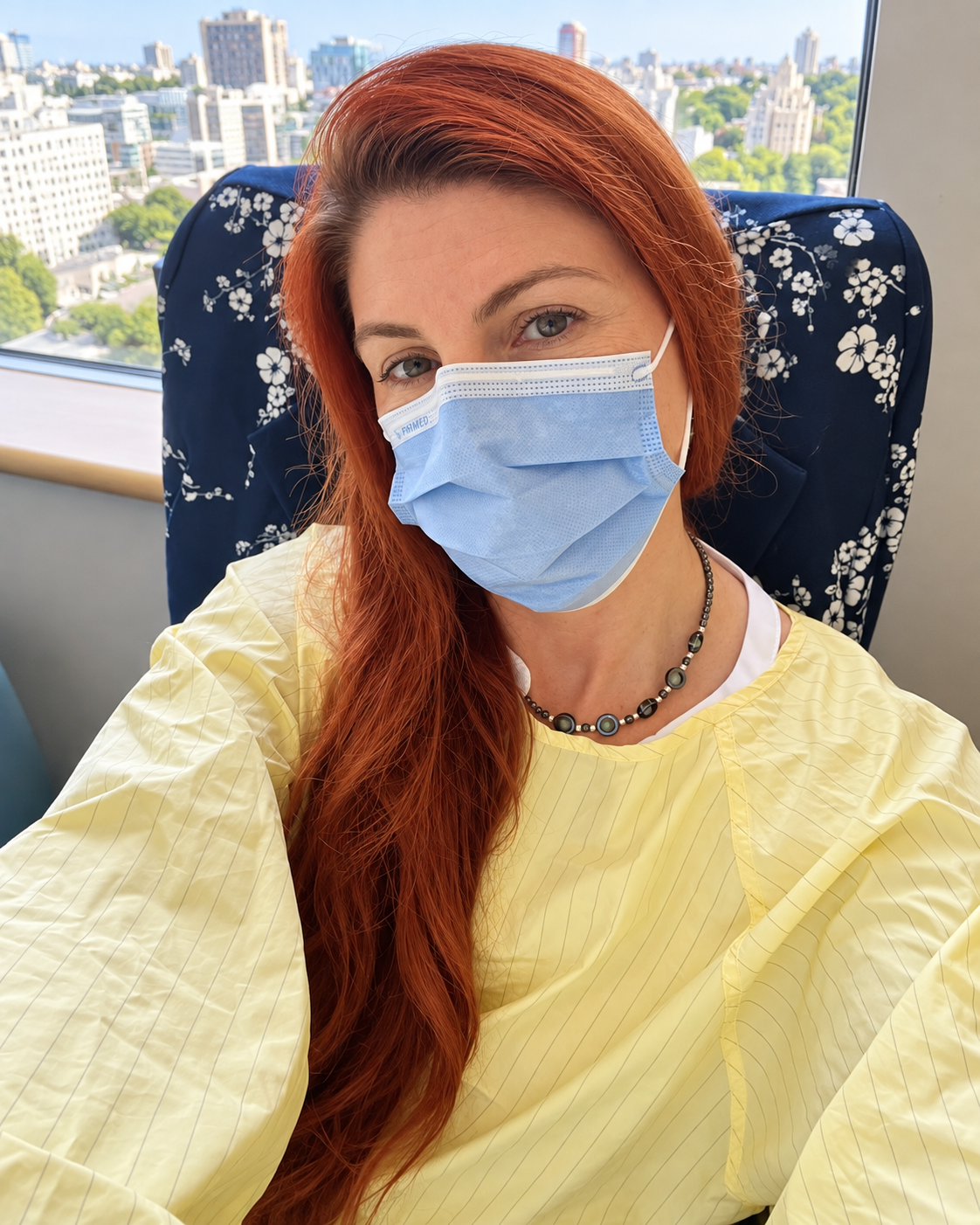 Harmony in her hospital gown and mask sitting vigil by the hospital window