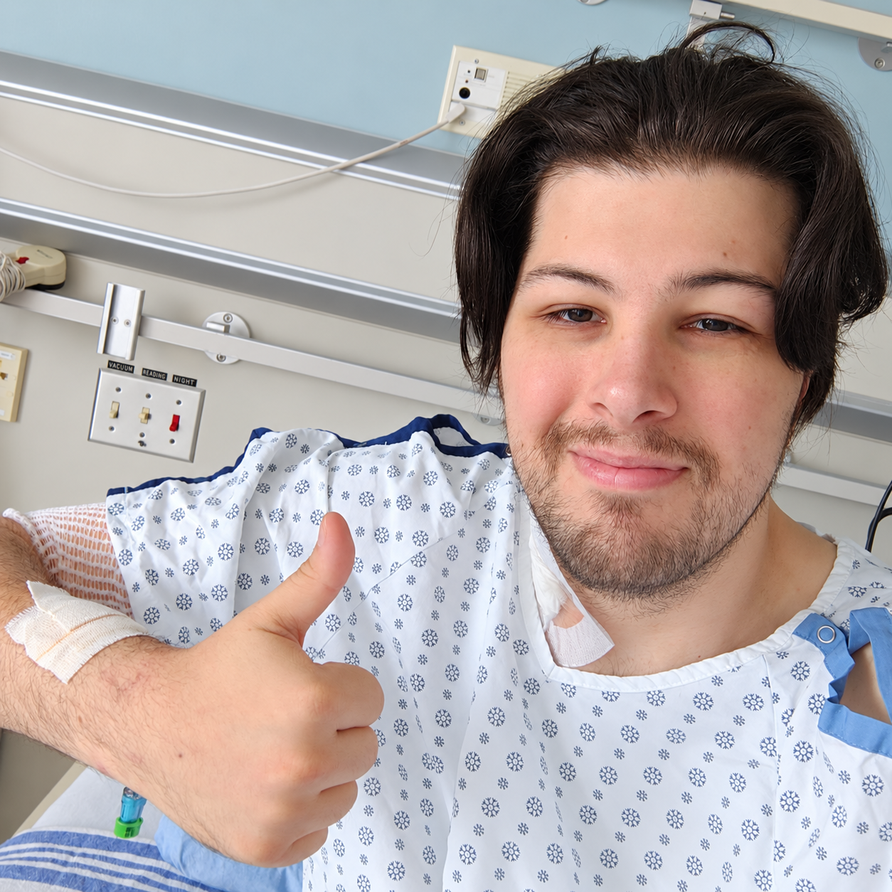 Winston smiling and giving a thumbs up from his hospital bed