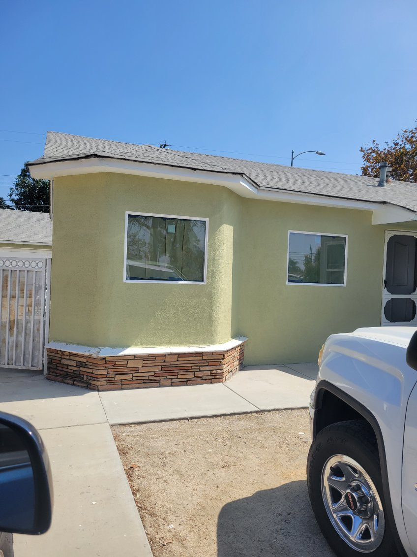 Freshly painted stucco exterior on residential home with stone base accent