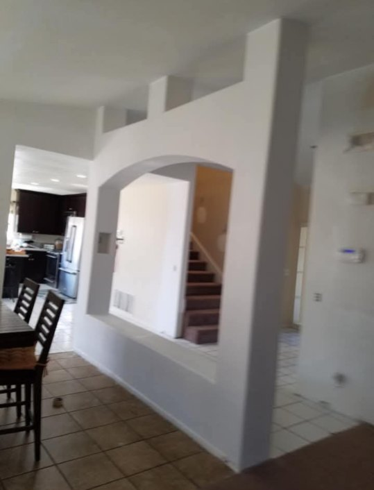 Custom architectural arched drywall pass-through and divider wall finished smooth