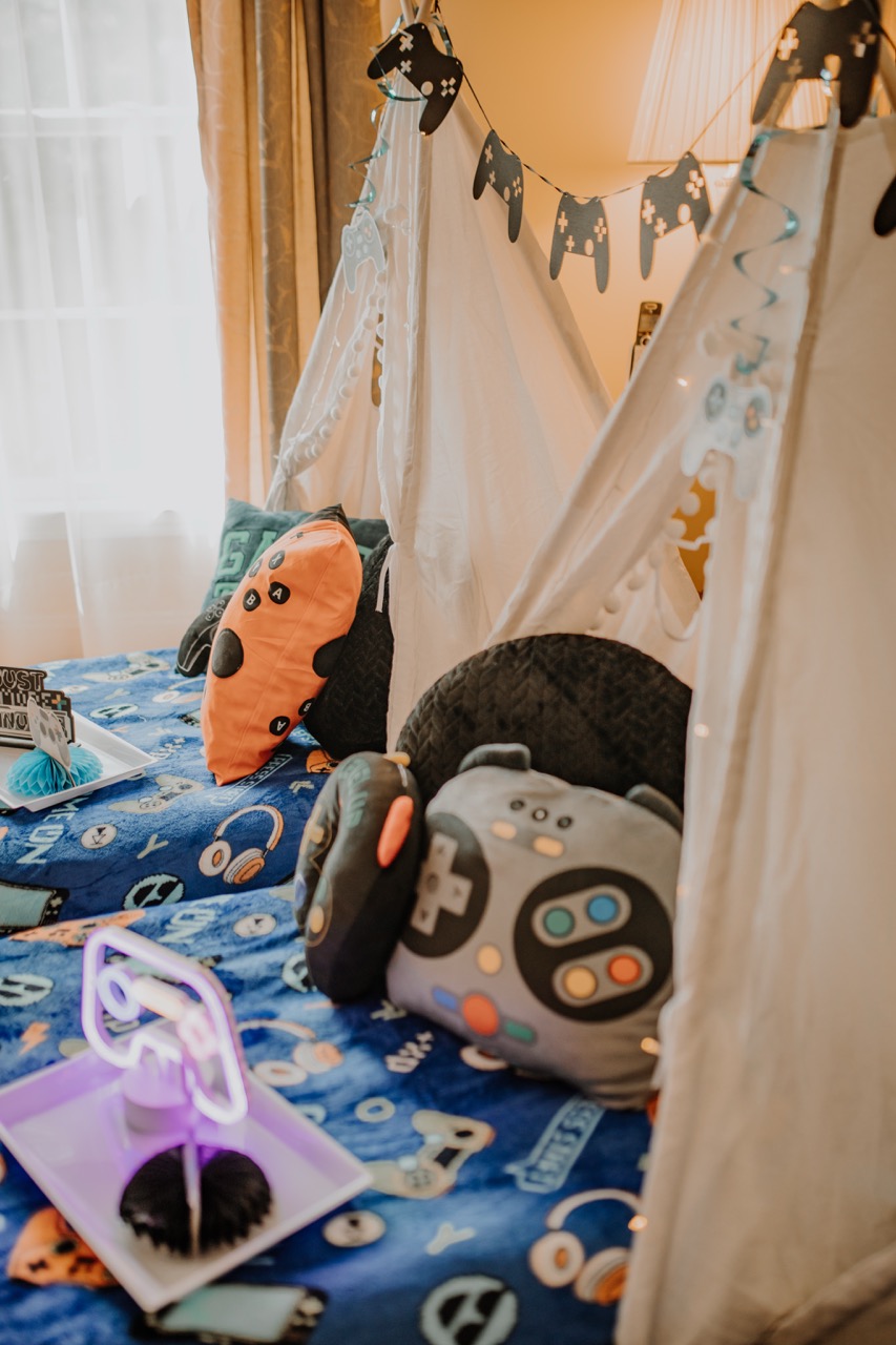 Close-up of Level Up teepee with gamer pillows, controller bunting, and LED tray light