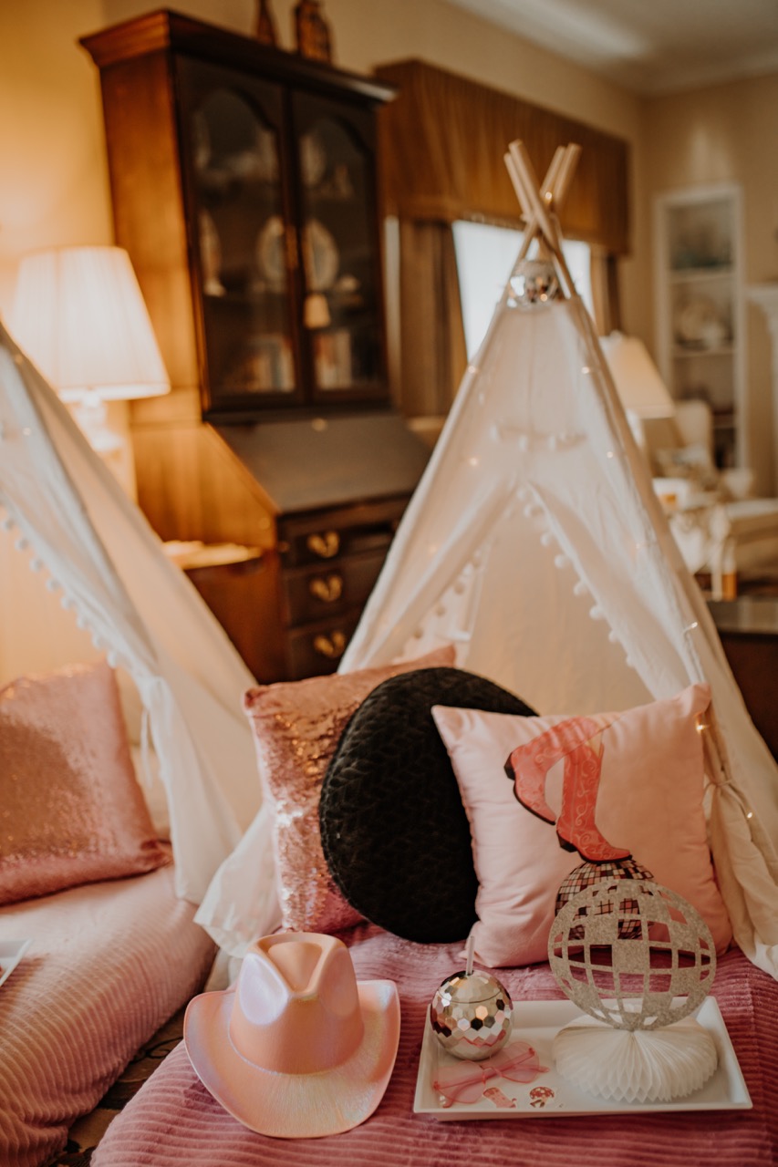 Wooden teepee frame with mini disco ball, sparkling cushions, and theme accessories
