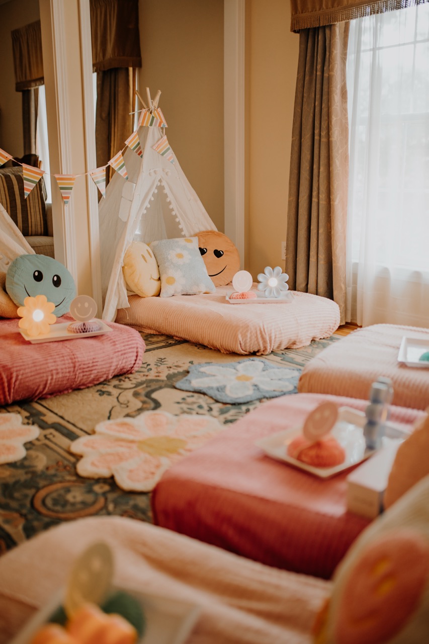 Flower Power teepee sleepover room with daisy rugs, pastel mattresses, and smiley decor