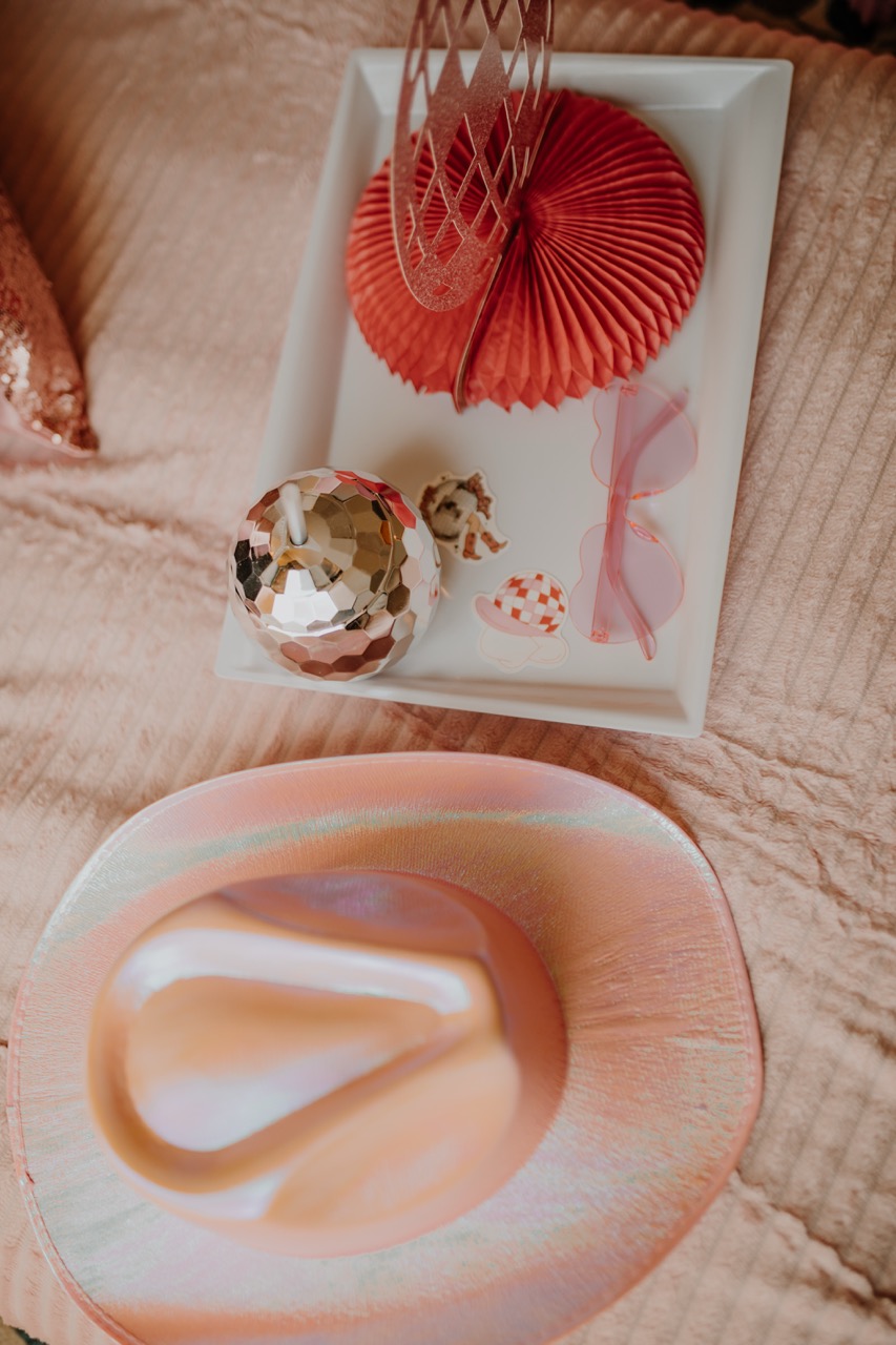 Shimmering pink cowgirl hat with disco ball cup, sunglasses, and tray decor