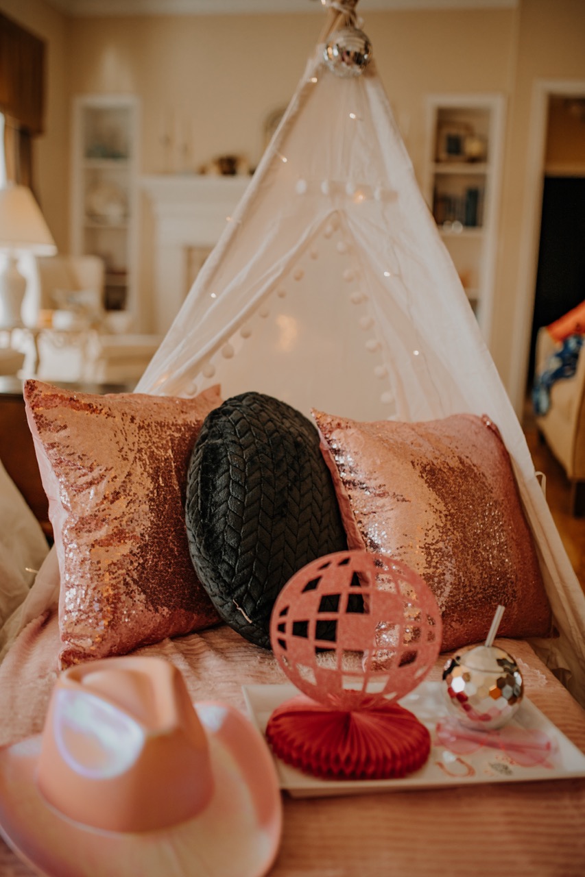 Teepee interior with rose gold sequin pillows, disco paper centerpiece, and tumbler