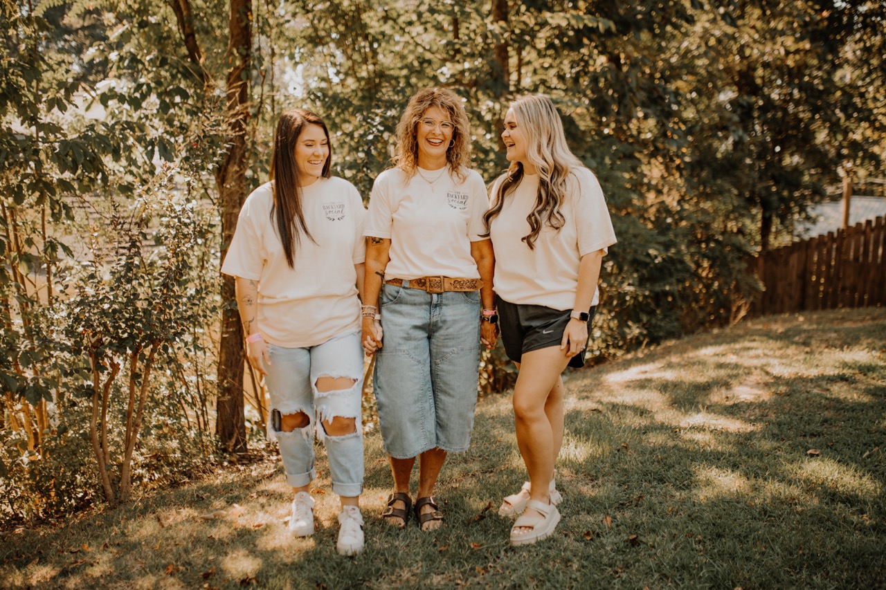The Backyard Social team smiling together in branded tees