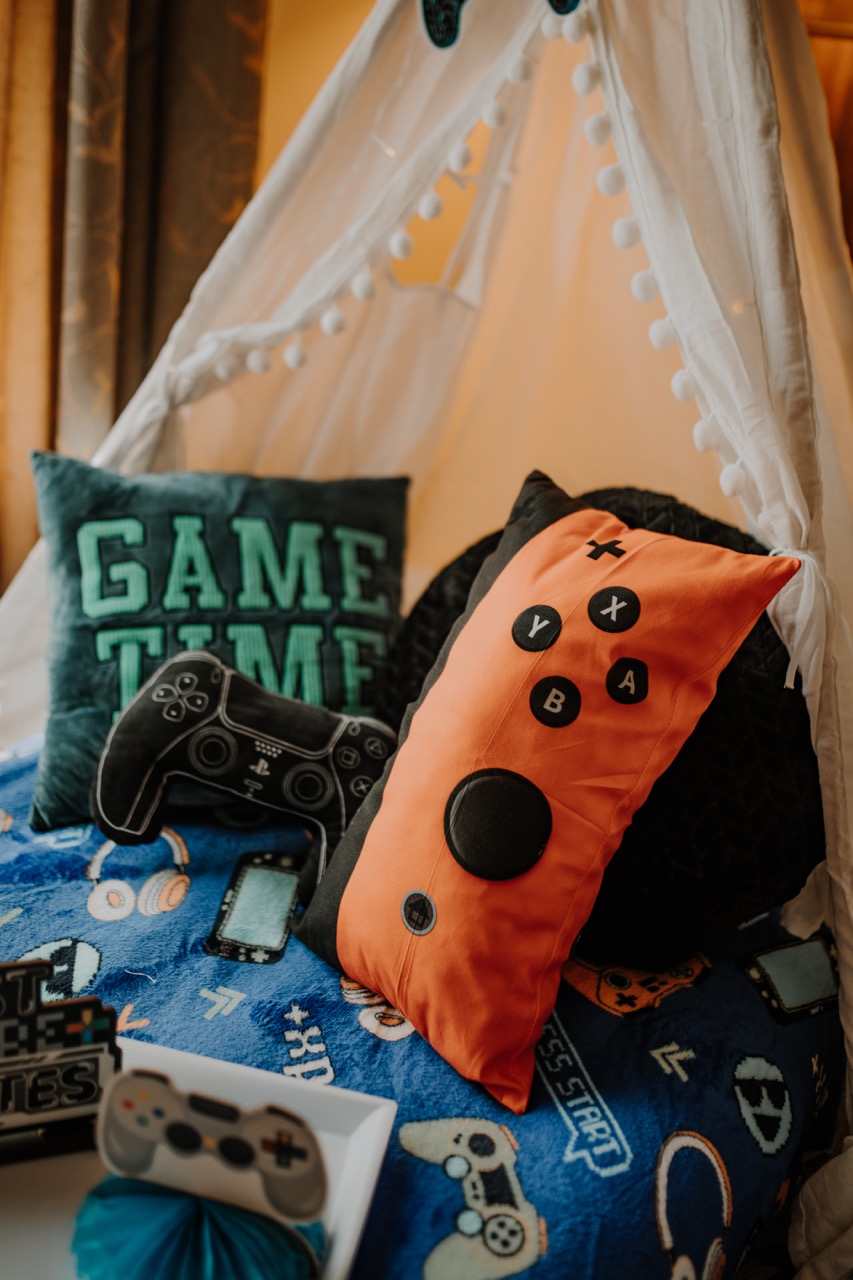 Game Time velvet pillow and bright orange gaming controller cushion on Level Up bedding