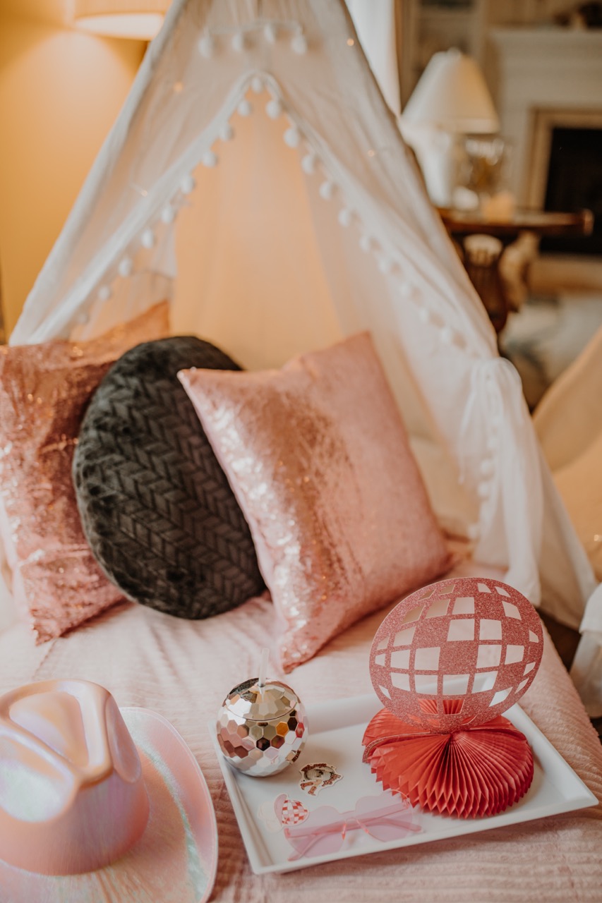 Single white canvas teepee with pom-pom trim, rose gold pillows, and disco tray accessories